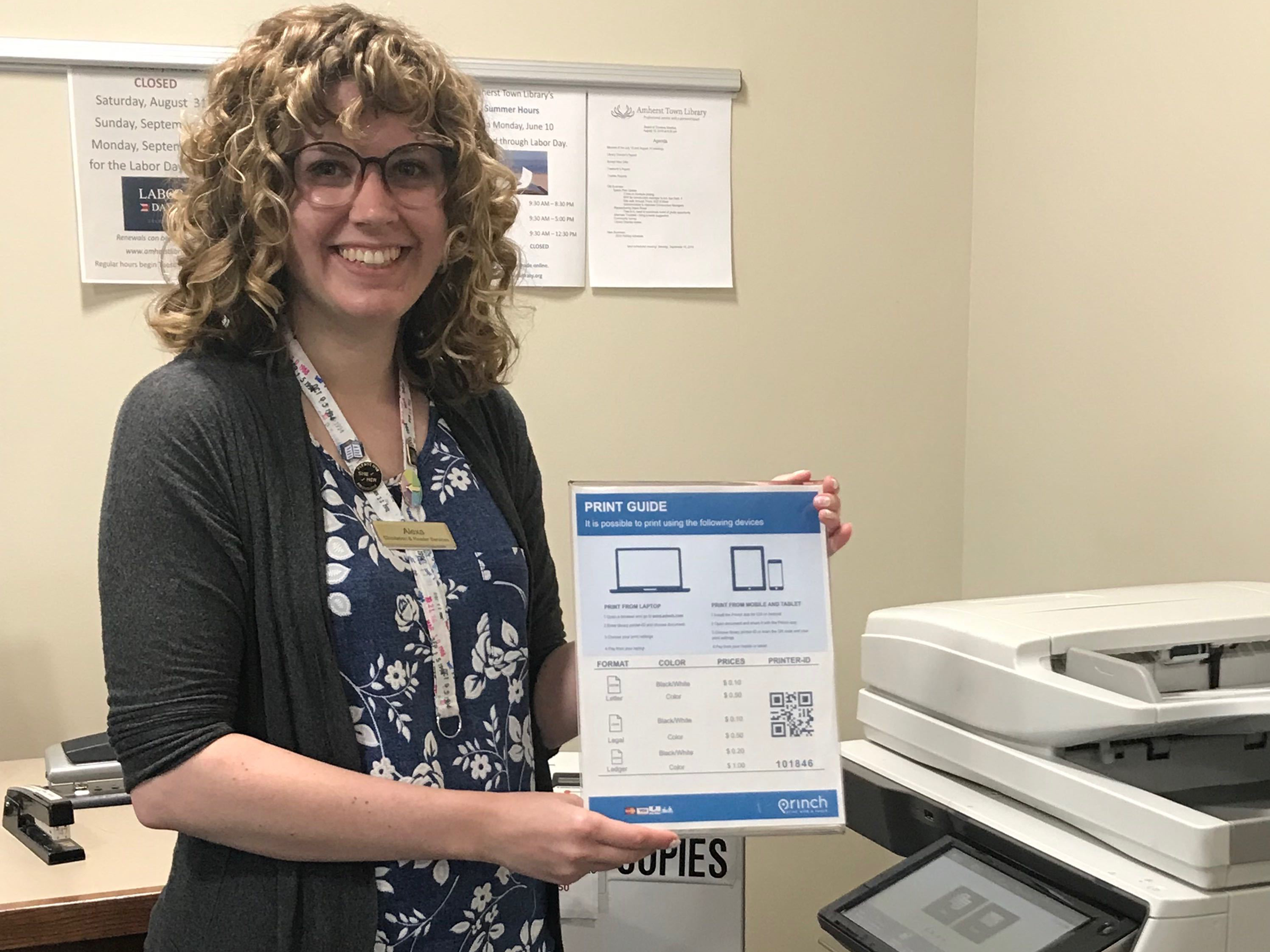Amherst librarian showing the Princh print guide poster at their library.