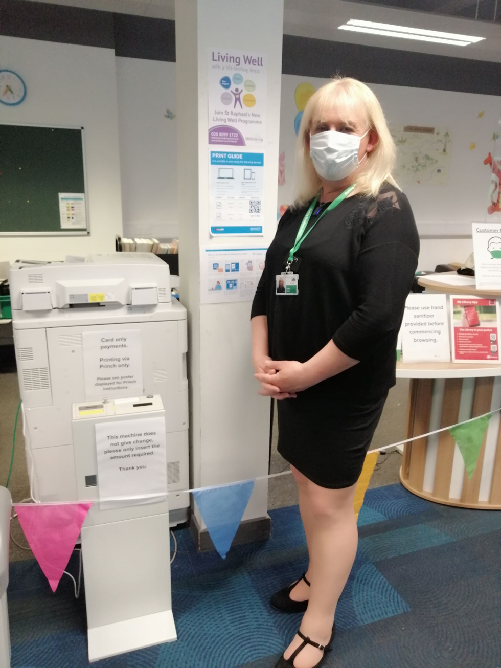 Sutton library staff standing in front of their printer and the Princh print guide poster.